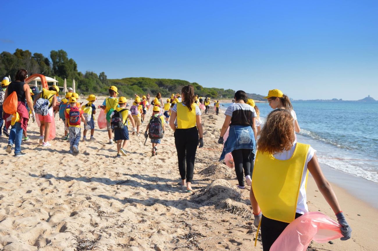 Gruppo di ragazzi in pettorina lungo la battigia durante un'attività in spiaggia
